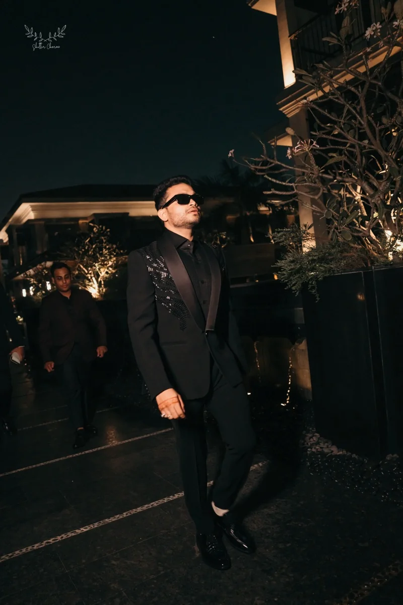 Groom in black at a night celebration in Kolkata