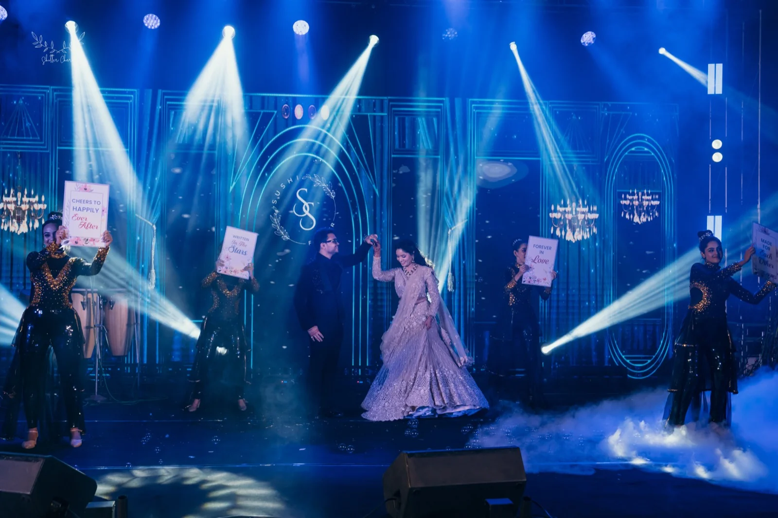 Couple twirling on stage during a dazzling sangeet performance