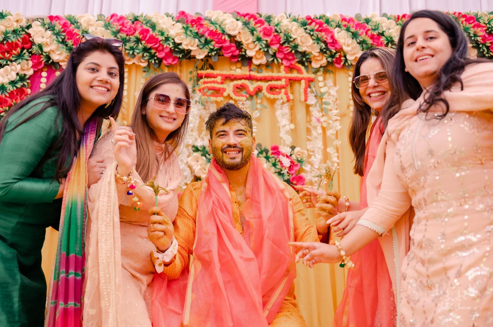 Groom covered in haldi celebrating with family at haldi ceremony