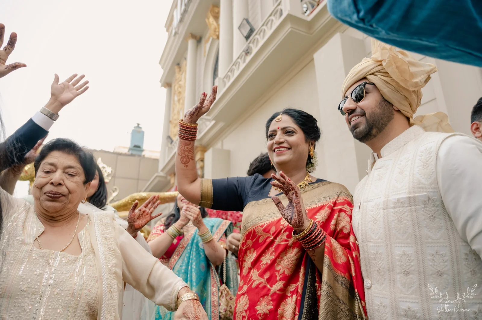 Family dancing joyfully around the groom during baraat celebrations