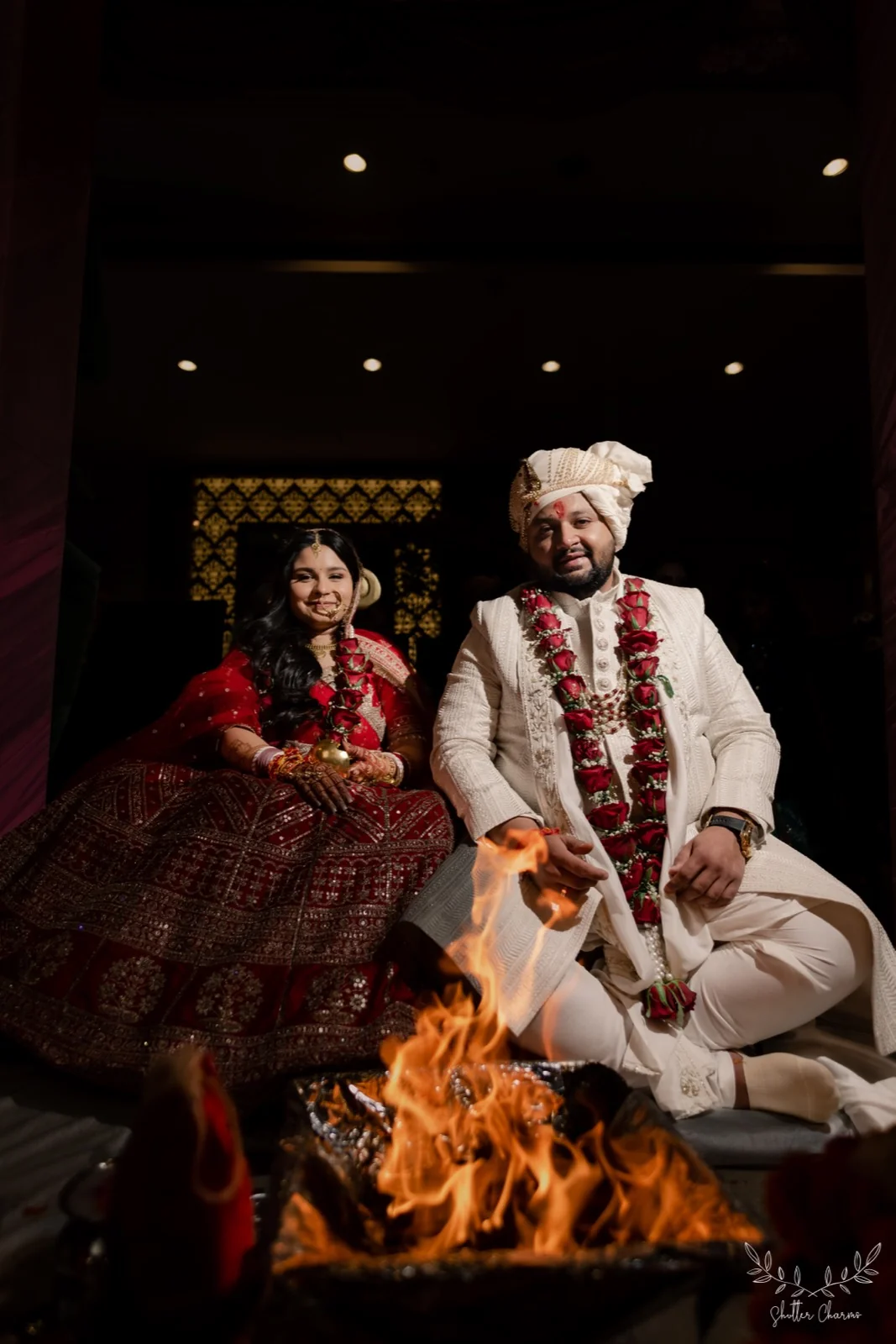 Bride and groom smiling beside the sacred fire during pheras