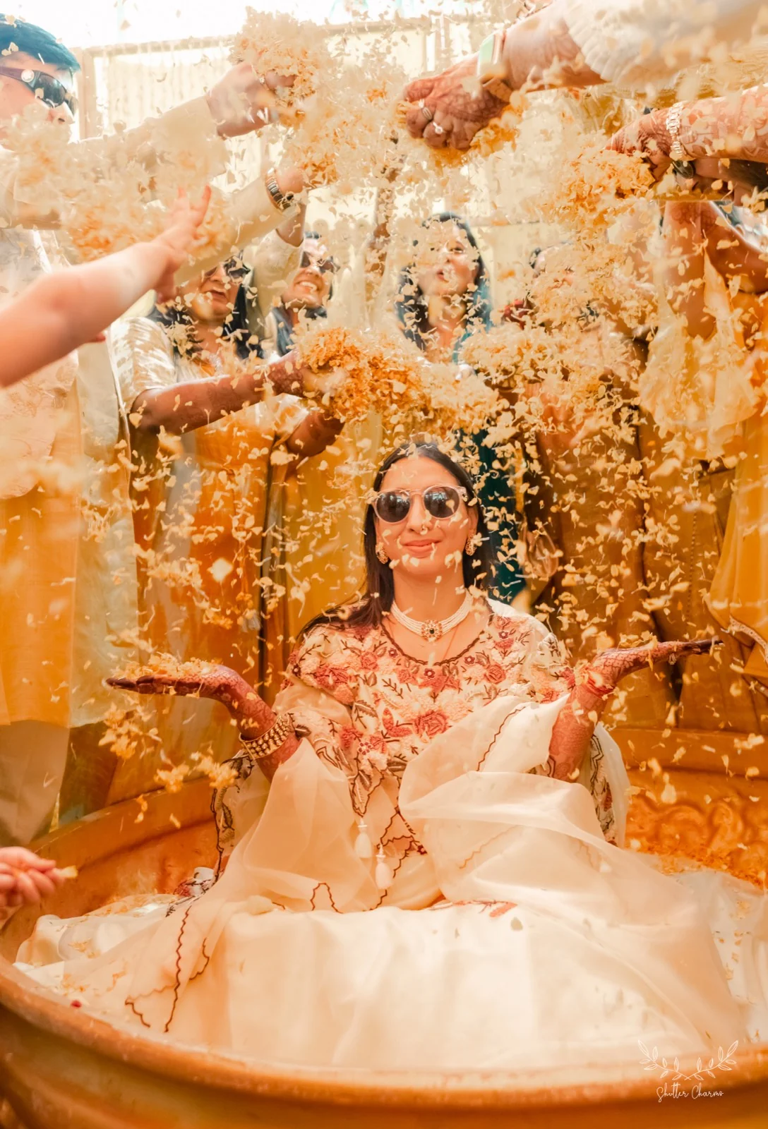 Bride showered with flower petals during her haldi ceremony