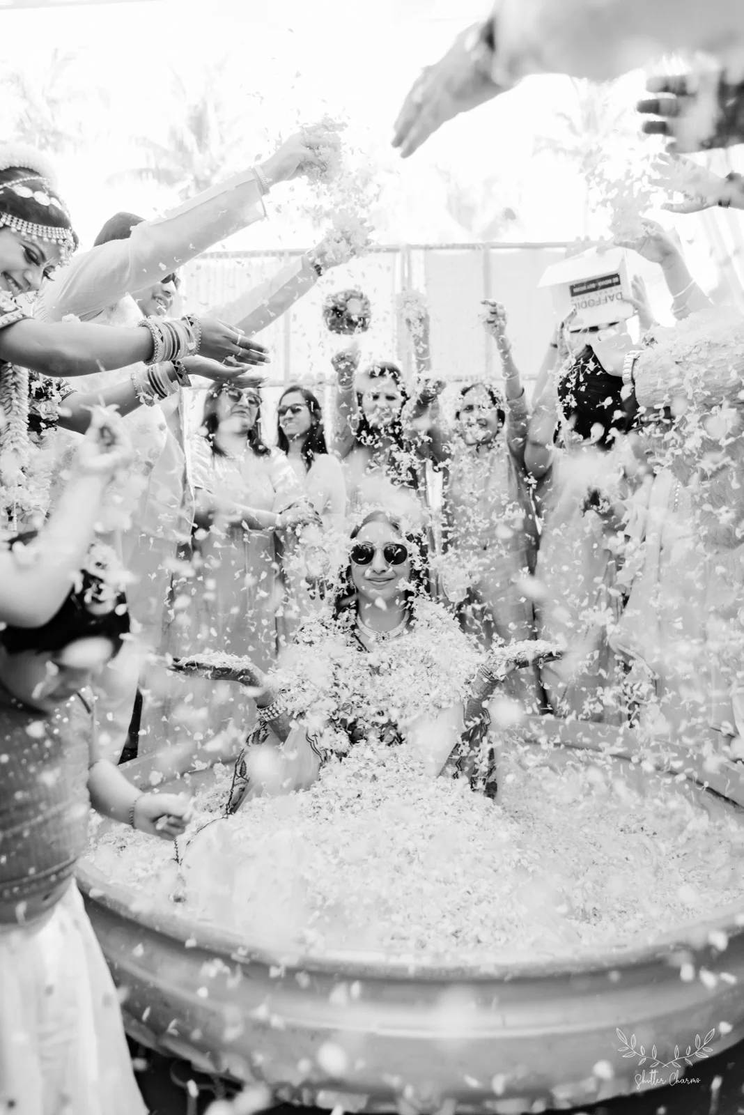 Black and white moment of bride amid a petal shower