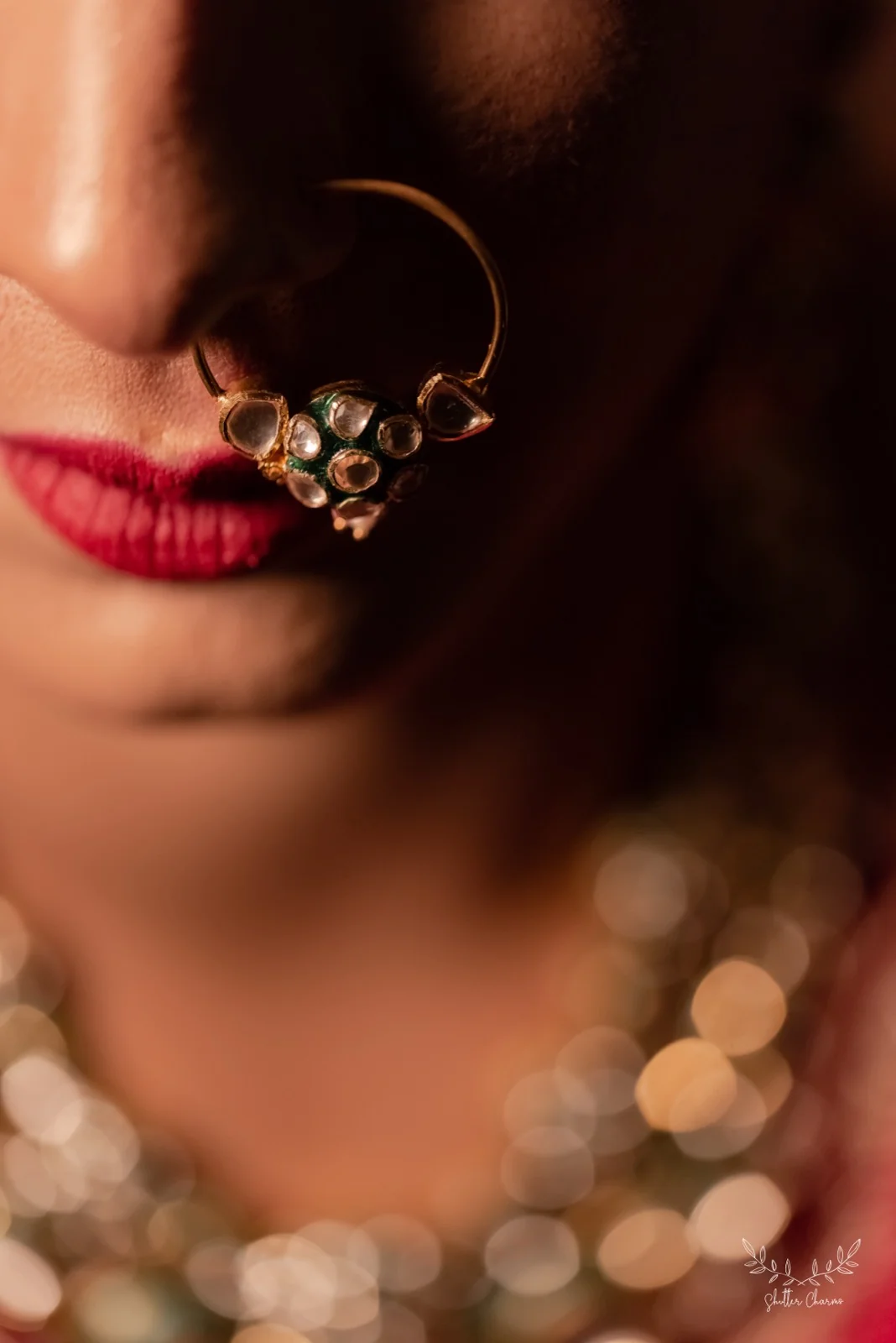 Close-up of bride's kundan nose ring and red lips