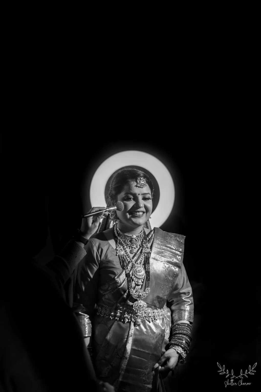 Black and white portrait of bride's makeup framed by ring light