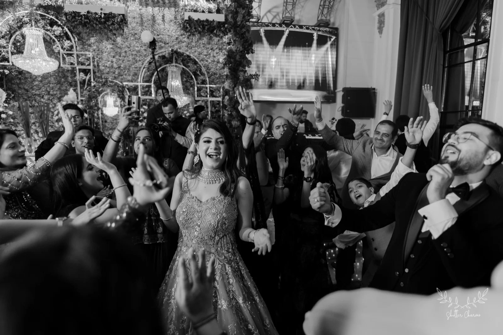 Bride dancing joyfully surrounded by cheering guests on the dance floor