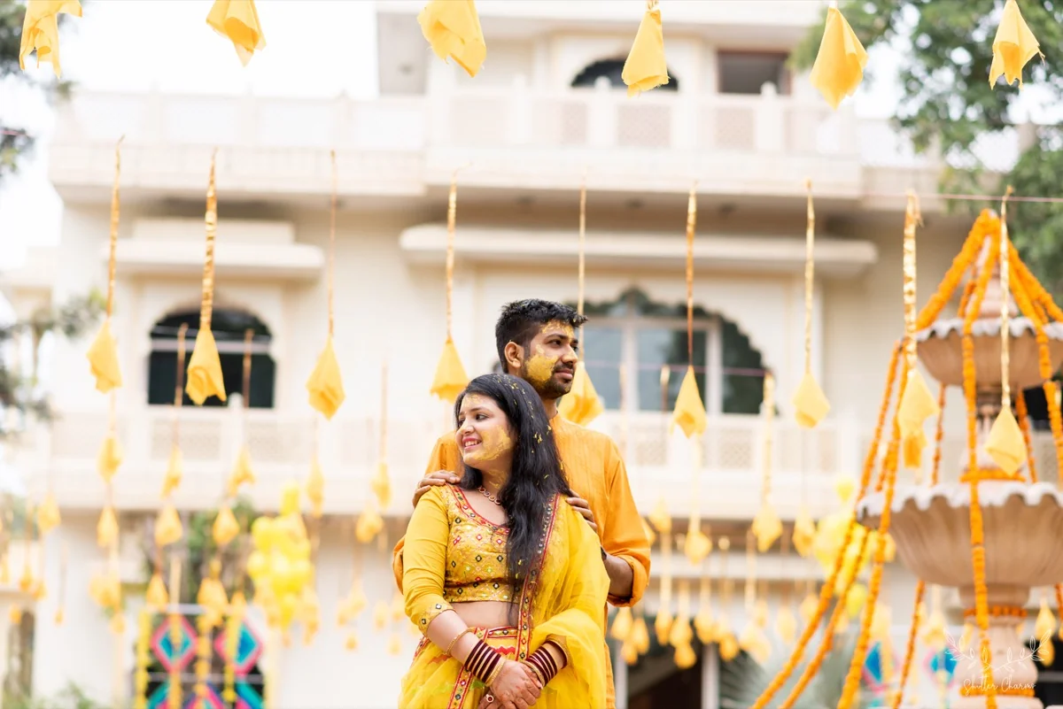 Couple at their haldi ceremony amid yellow decorations
